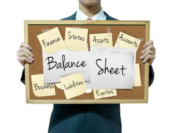 Business man holding board on the background, Balance Sheet